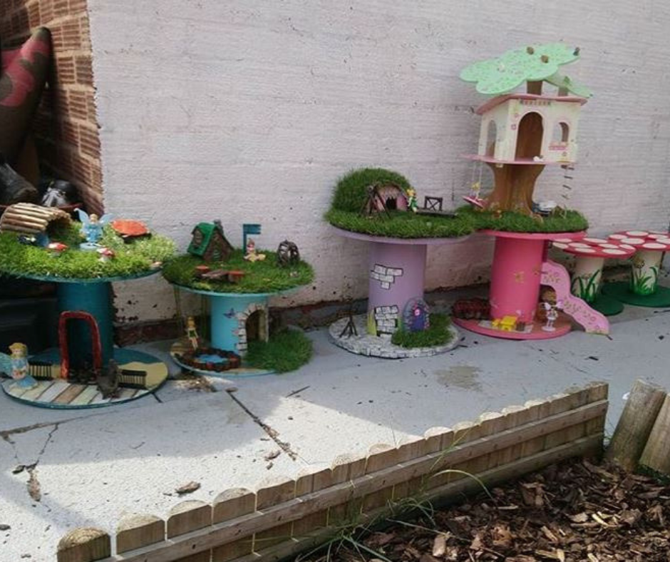 Upcycled cable reel that has been turned into a painted Fairy Garden, using cheap and recycled paint from Community RePaint Coventry.