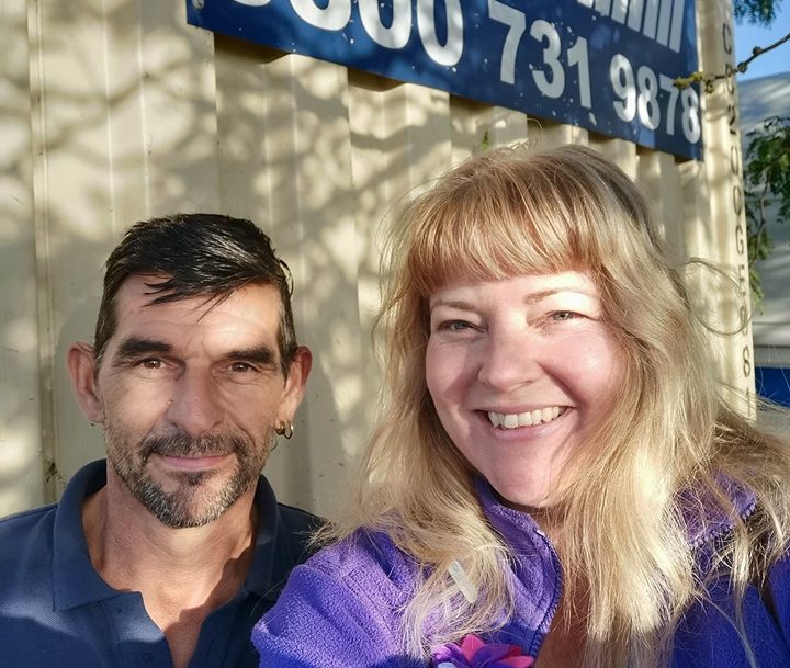 A photo of two staff members at Community RePaint Cambridgeshire standing outside their paint donation container.