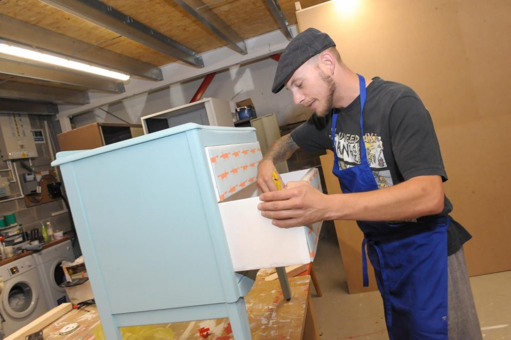 A member of staff at Community RePaint Loughborough upcycles a