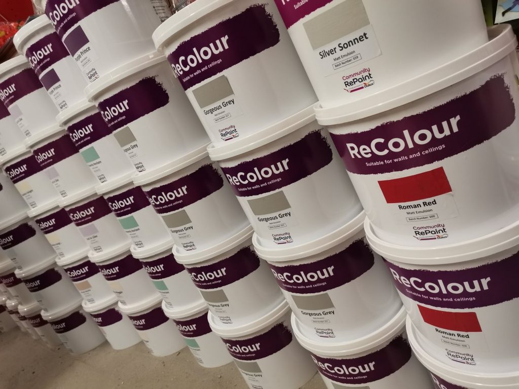 A photo of a range of our low cost and environmentally friendly paint. The ReColour matt emulsion paint and silk emulsion paint is sold in 5 litre plastic containers. There are a range of colour paints on show including Gorgeous Grey, Roman Red and Silver Sonnet.