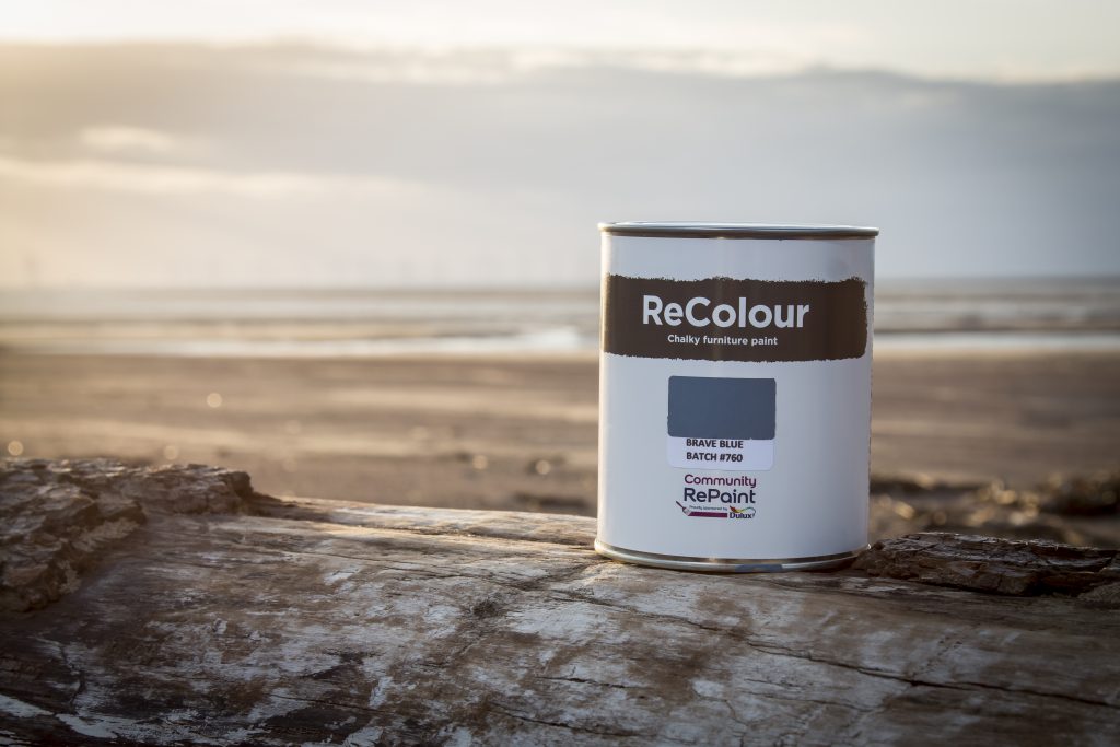 Promotional photo of ReColour chalk paint container with sunset in background.